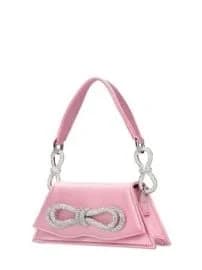 A product photo of a small pink handbag with a decorative infinity symbol design on the front flap. The bag has a structured triangular shape and features a satin-like pink fabric material. The infinity symbol is crafted with silver-colored metalwork and crystal embellishments. The bag has a single shoulder strap made of the same pink material, attached with silver infinity-shaped hardware. The strap is thin and adjustable. The bag is photographed against a pure white background, positioned at a slight angle to show its three-dimensional form. The lighting is bright and even, creating subtle shadows beneath the bag. The image is a professional product shot with sharp focus and high resolution, showing the details of the crystal embellishments and the sheen of the fabric material.